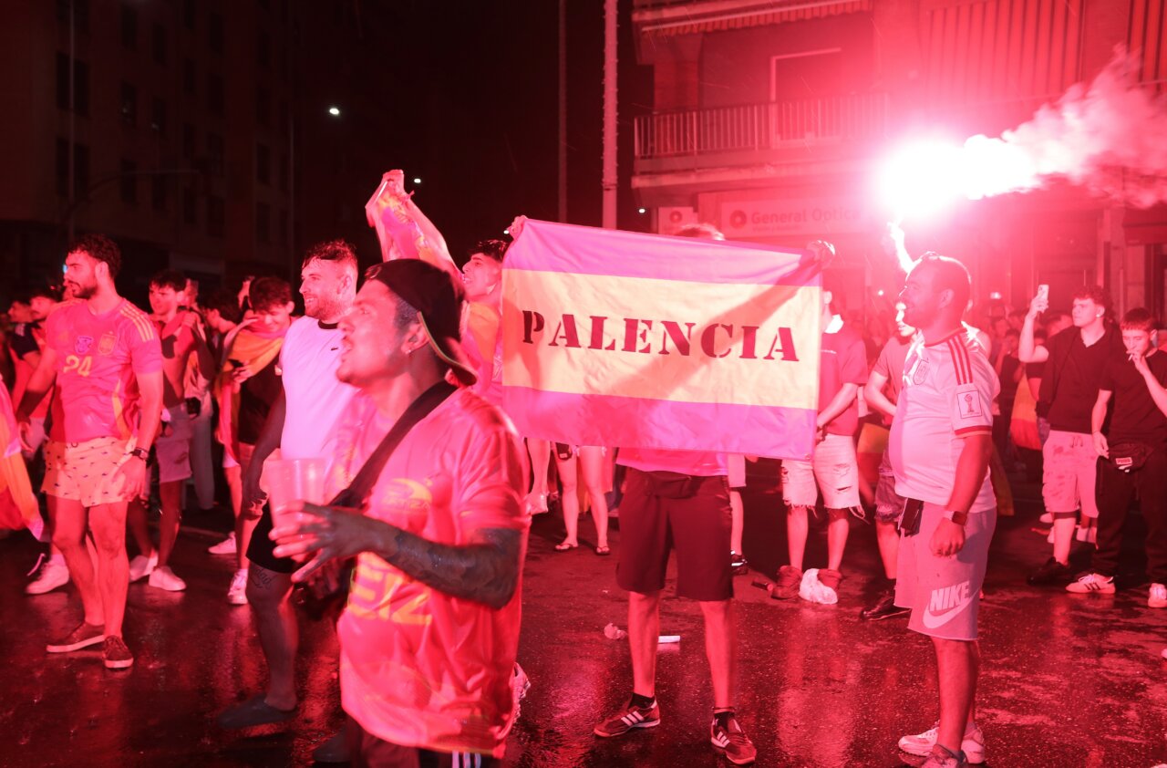 Aficionados celebrando la victoria de España con banderas en Palencia