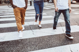 Tres personas cruzando una calle en una zona urbana