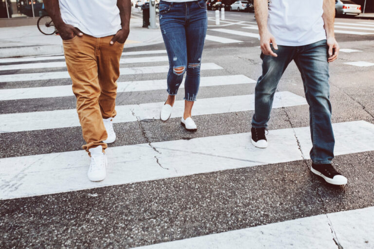 Tres personas cruzando una calle en una zona urbana