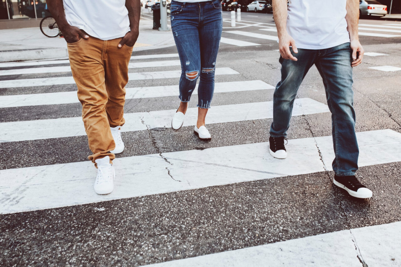 Tres personas cruzando una calle en una zona urbana