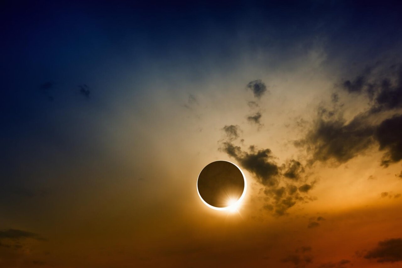Eclipse solar con nubes en un cielo atardecido