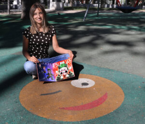Psicóloga Anabel Martín con libro sobre emociones en un parque infantil