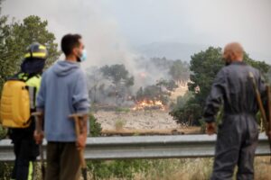 Personas observando un incendio forestal en Burgohondo, Ávila.
