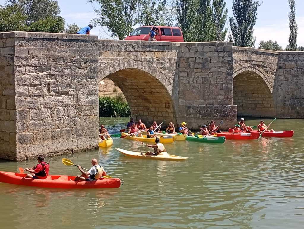 Participantes en el concurso de piraguas en el río Carrión durante la Fiesta Asturiana.