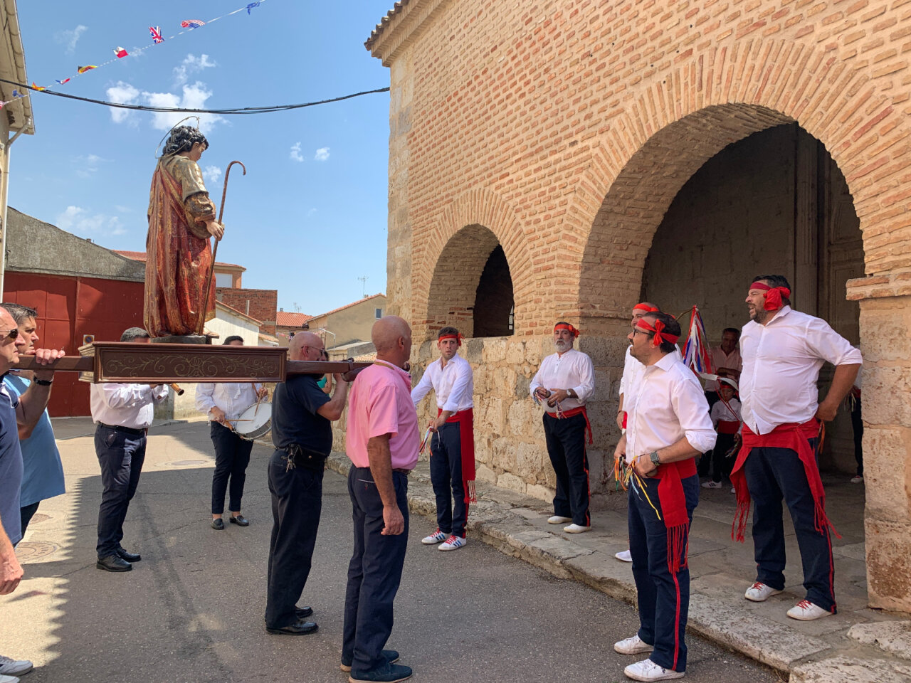 Grupo de personas llevando una estatua durante las fiestas de San Mamés en Magaz de Pisuerga