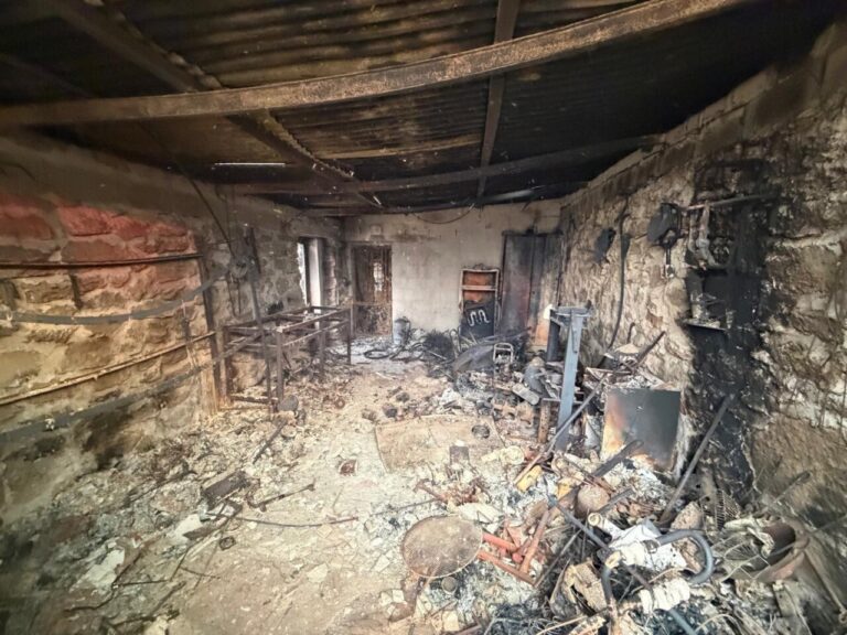 Interior de una finca quemada en El Hoyo, Palencia, con escombros y cenizas.