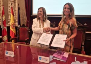 Dos mujeres firmando un convenio sobre el programa Unidosis en Palencia
