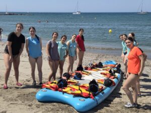 Grupo de jóvenes en la playa con tablas de paddle surf