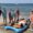Grupo de jóvenes en la playa con tablas de paddle surf
