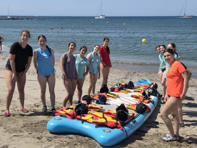 Grupo de jóvenes en la playa con tablas de paddle surf