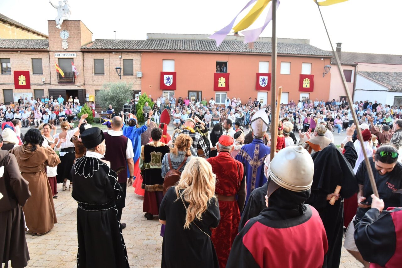 Vecinos de Husillos recrean escenas históricas en una plaza llena de gente.
