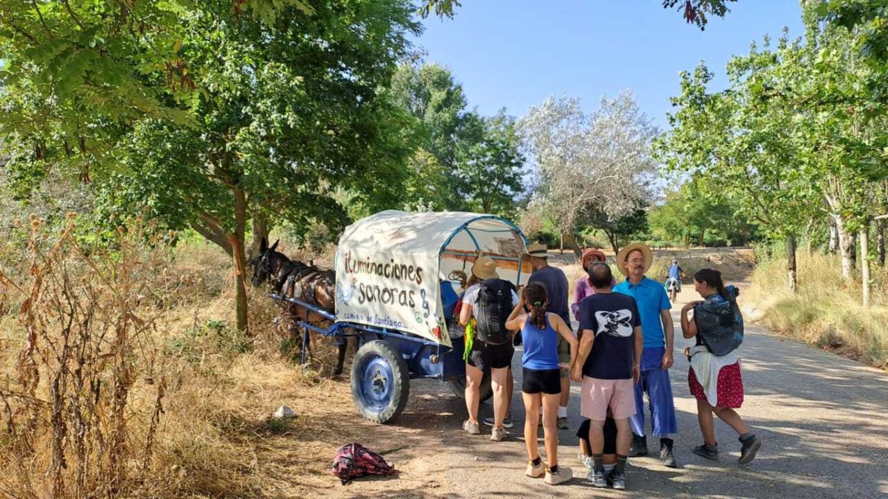 Grupo de personas alrededor de un carro en el Camino de Santiago