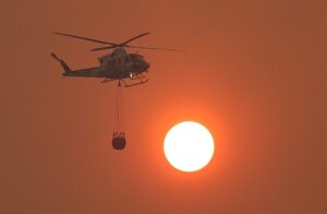 Helicóptero realizando labores de extinción de incendios en Ávila al atardecer