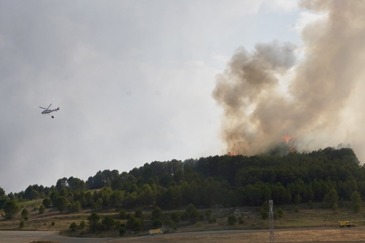 Helicóptero apagando un incendio cerca de un bosque en Íscar