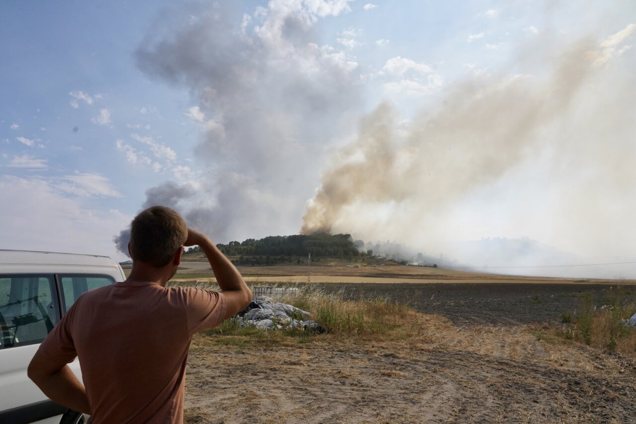 Persona observando el incendio en Íscar junto a un vehículo