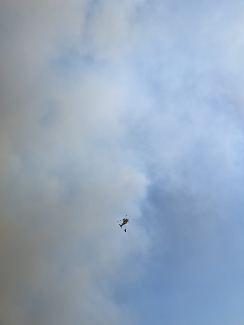 Helicóptero sobrevolando un incendio forestal en Valdeolmillos