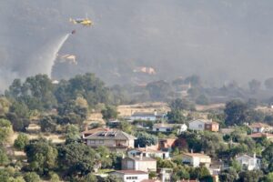 Helicóptero apagando incendio cerca de viviendas en el Valle del Tiétar