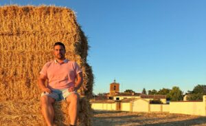 Jesús Merino sentado en un montón de paja en Revenga de Campos
