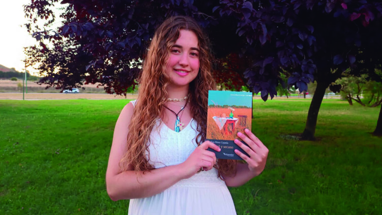 Joven poeta Eva Pérez Cepeda sosteniendo su libro en un entorno natural