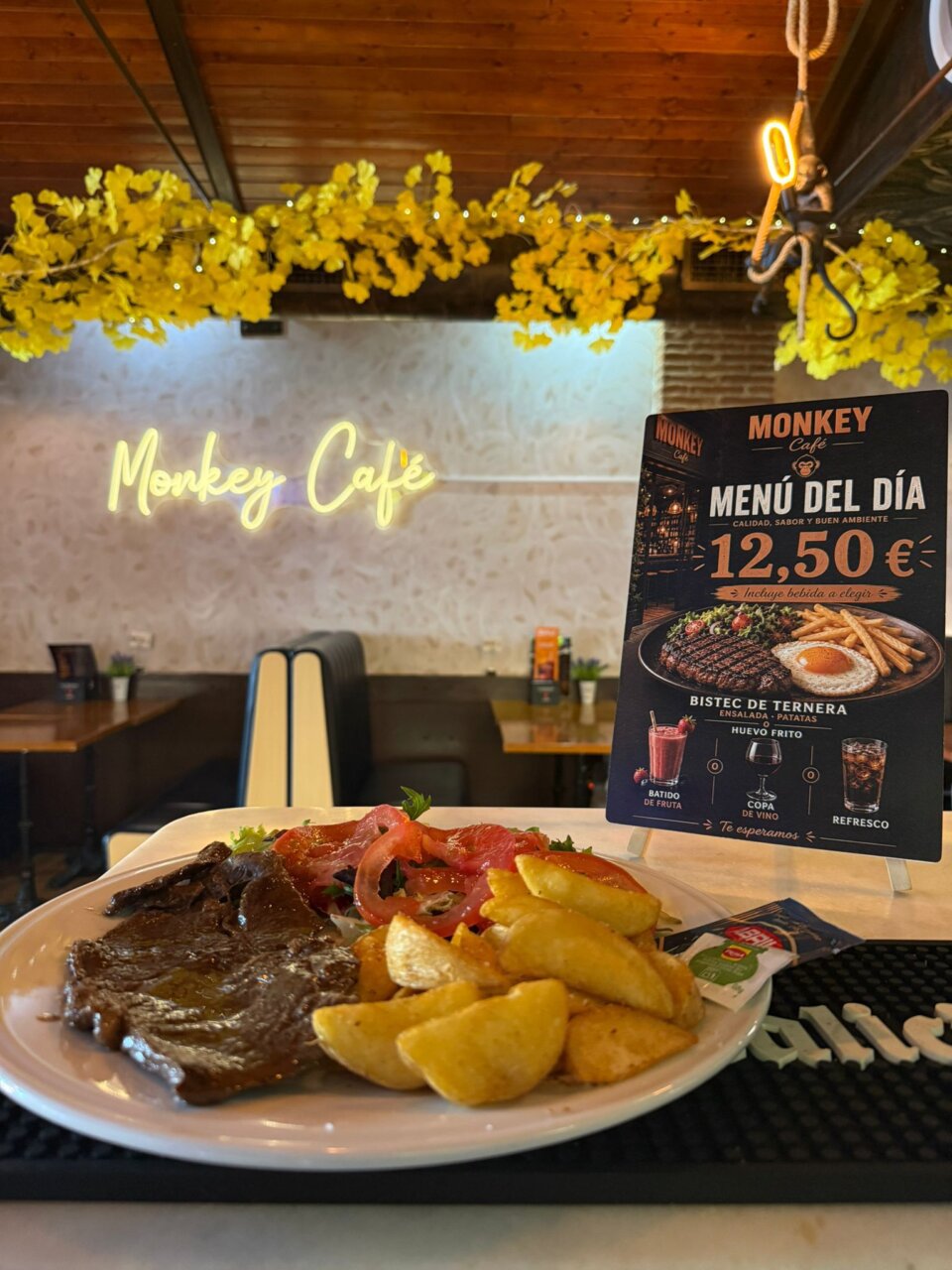 Plato de bistec de ternera con ensalada y patatas en Monkey Café
