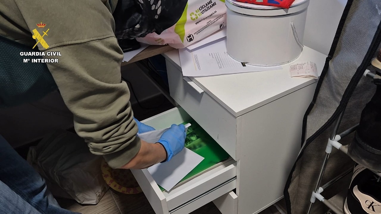 Agente de la Guardia Civil revisando un cajón durante una operación policial