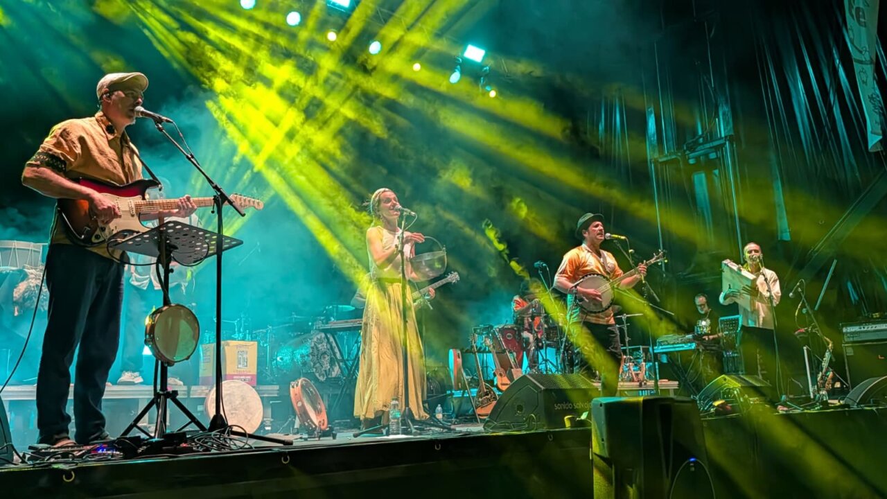 Actuación musical en el PipaFest de Villada con luces y músicos en el escenario.