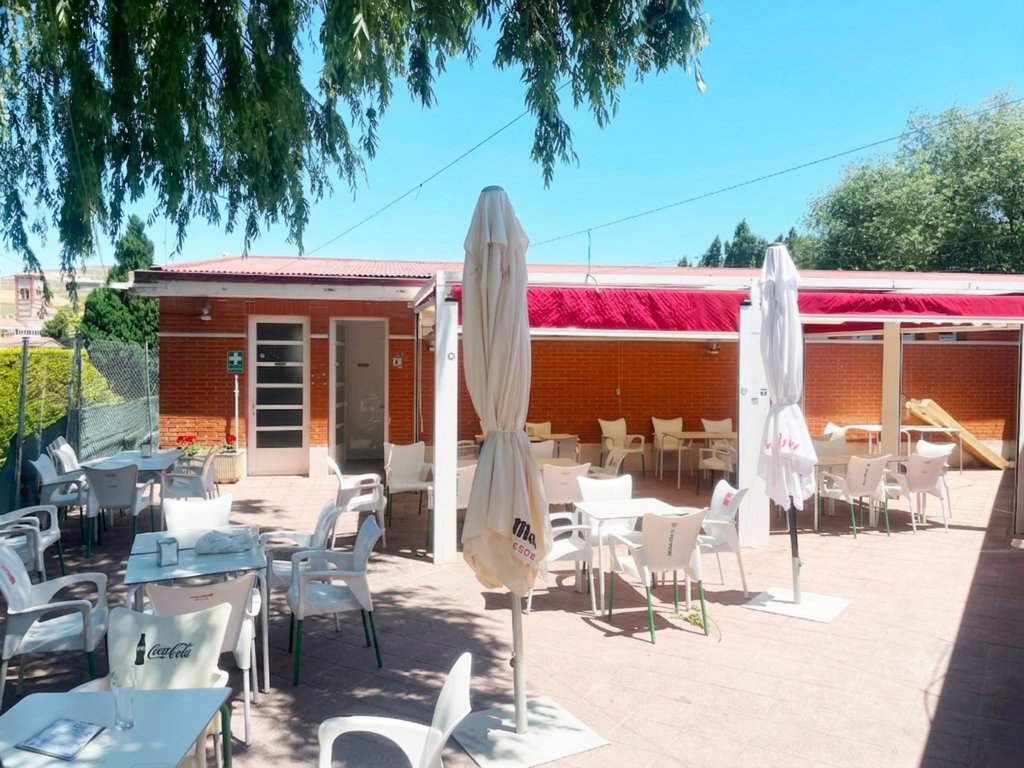 Terraza del bar en las piscinas de Antigüedad con mesas y sillas