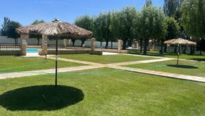 Vista de las piscinas de Paredes de Nava con sombrillas y césped
