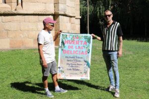 Dos personas sosteniendo un cartel de La Huerta de las Delicias