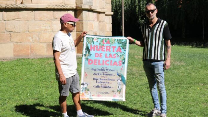 Dos personas sosteniendo un cartel de La Huerta de las Delicias