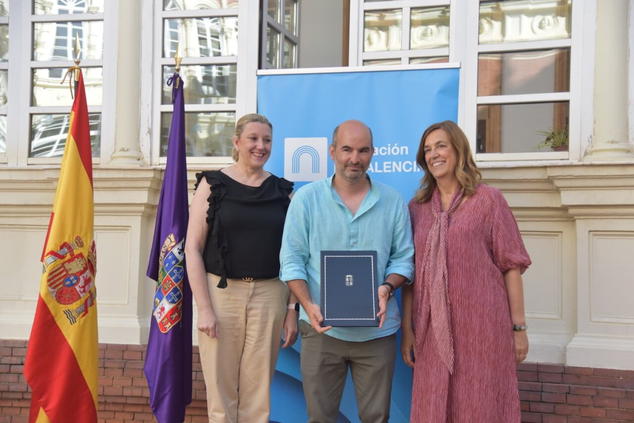 Tres personas posando en un evento sobre vivienda social en Palencia