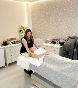 Esteticista realizando un tratamiento facial en un cliente en el salón Moon Beauty.