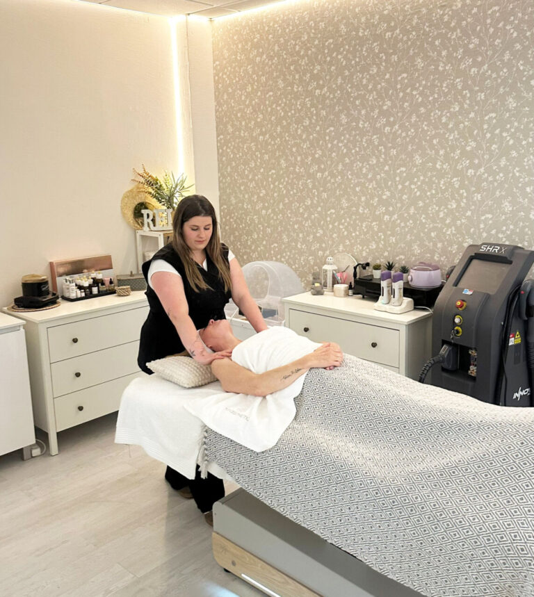 Esteticista realizando un tratamiento facial en un cliente en el salón Moon Beauty.