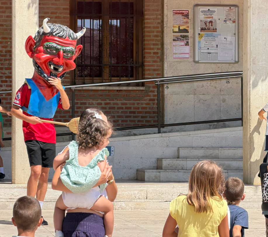 Niños observando un personaje con máscara en las fiestas de San Cristóbal