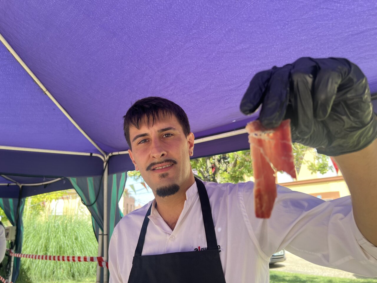 Cortador de cecina mostrando un plato en la feria del vino