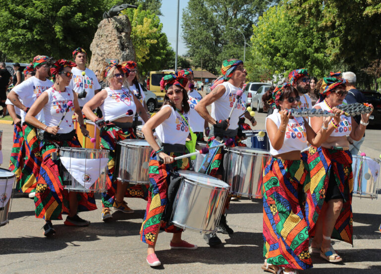 Grupo de personas con trajes coloridos tocando instrumentos en un desfile festivo