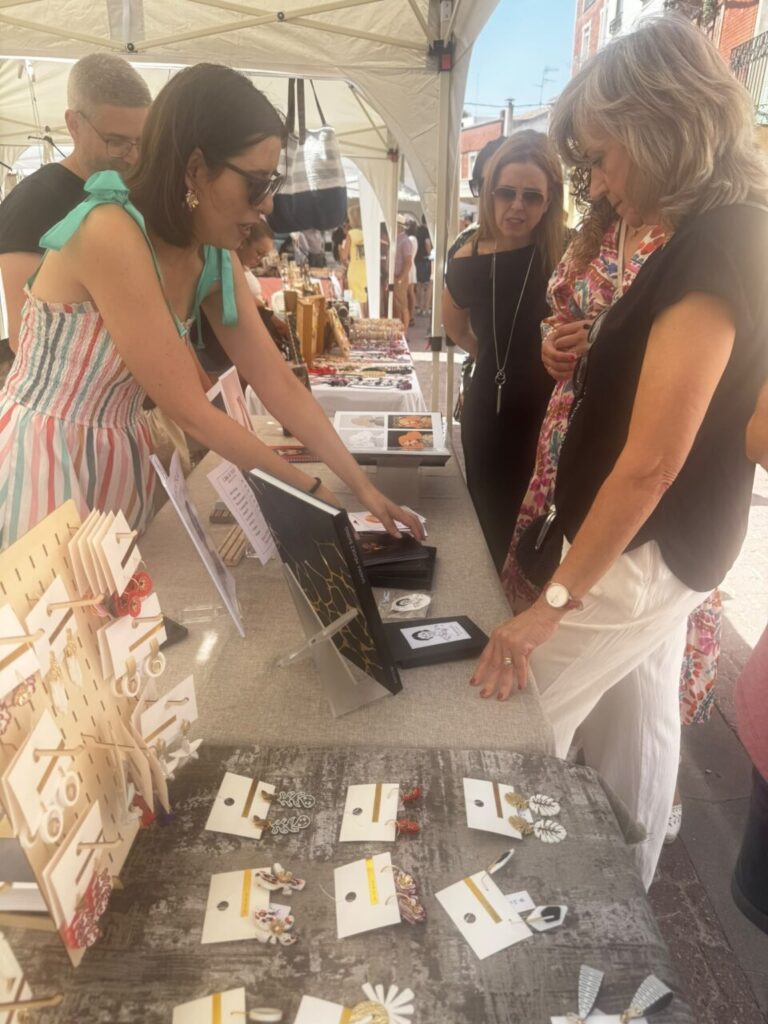 Mujeres observando artículos de bisutería en un mercado al aire libre
