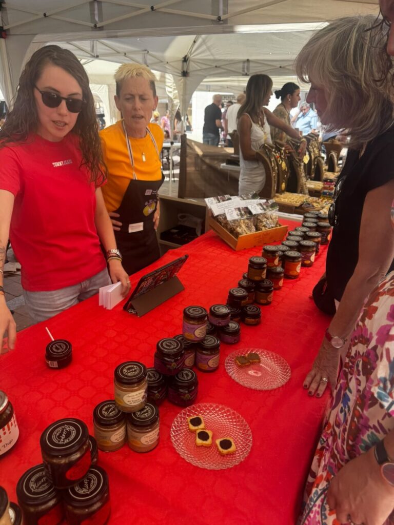 Mujeres en un mercado mostrando productos de gastronomía local