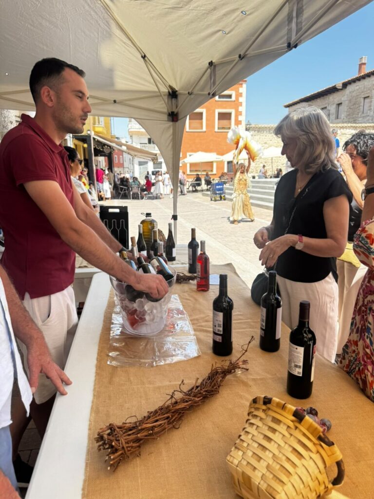Persona sirviendo vino en un evento al aire libre en Baltanás