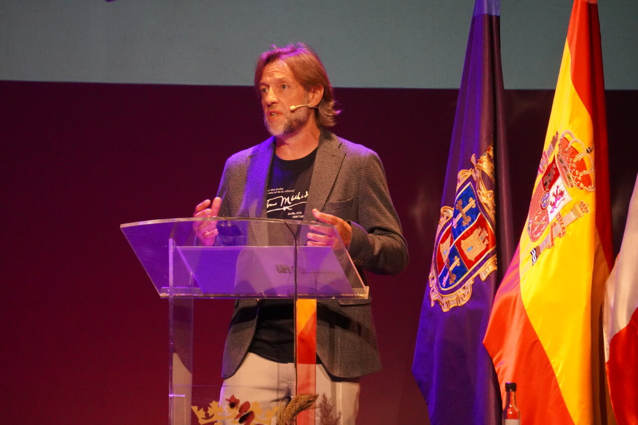 Hombre hablando en un escenario durante el pregón literario de San Antolín 2026.