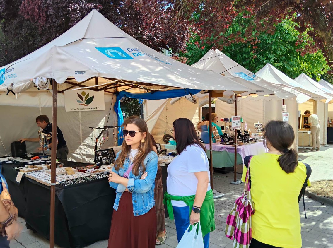Visitantes en la feria del Camino Olvidado en Guardo con puestos de artesanía