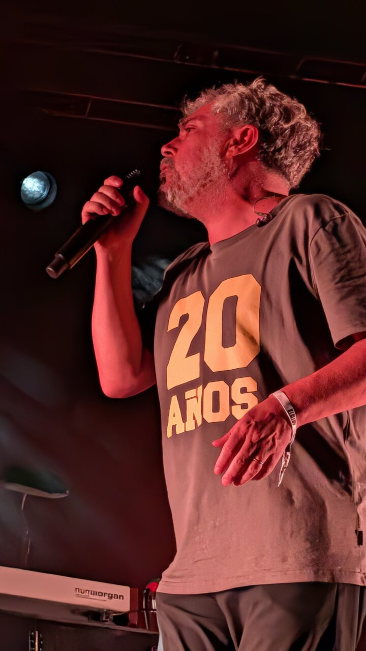 Cantante en concierto con camiseta que dice 20 años