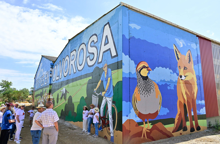 Mural colorido en Polvorosa de la Valdavia con personas observando