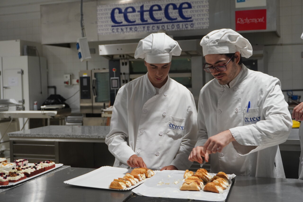 Alumnos del CETECE decorando pasteles en una cocina profesional