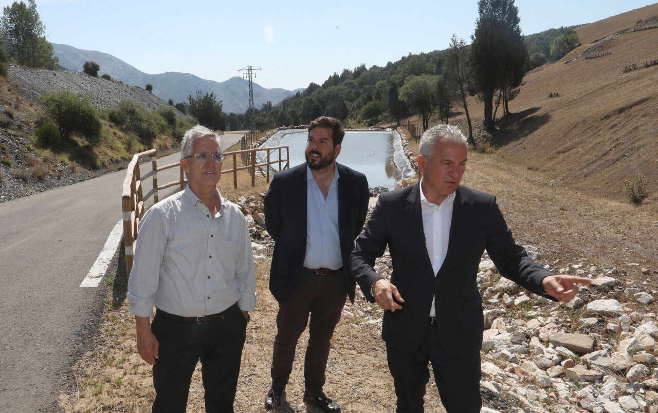 Tres hombres discutiendo sobre la renaturalización de antiguas minas en Velilla del Río Carrión