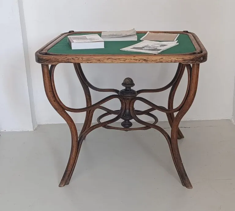 Mesa de madera con objetos sobre ella en una instalación artística