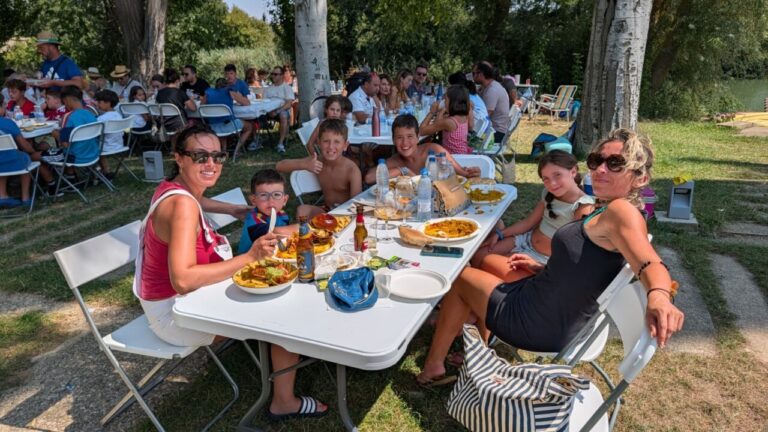 Familias disfrutando de una paellada junto al río Carrión en Husillos