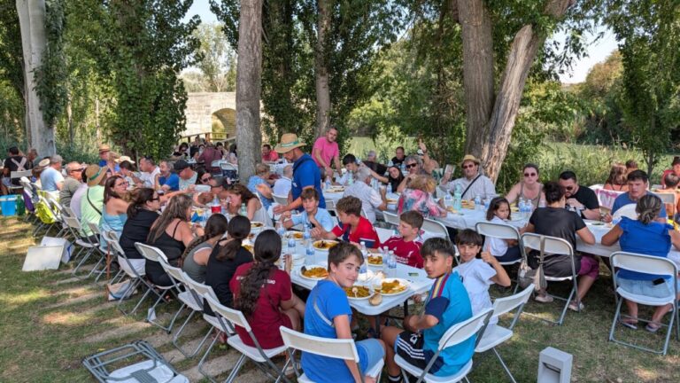 Personas disfrutando de una paellada en las fiestas de Husillos junto al río Carrión