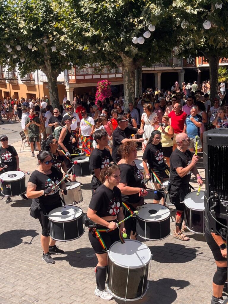 Grupo de personas tocando tambores en un desfile festivo