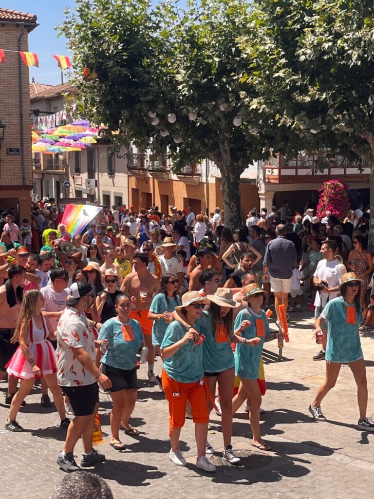Desfile festivo con participantes en coloridos trajes en Herrera de Pisuerga